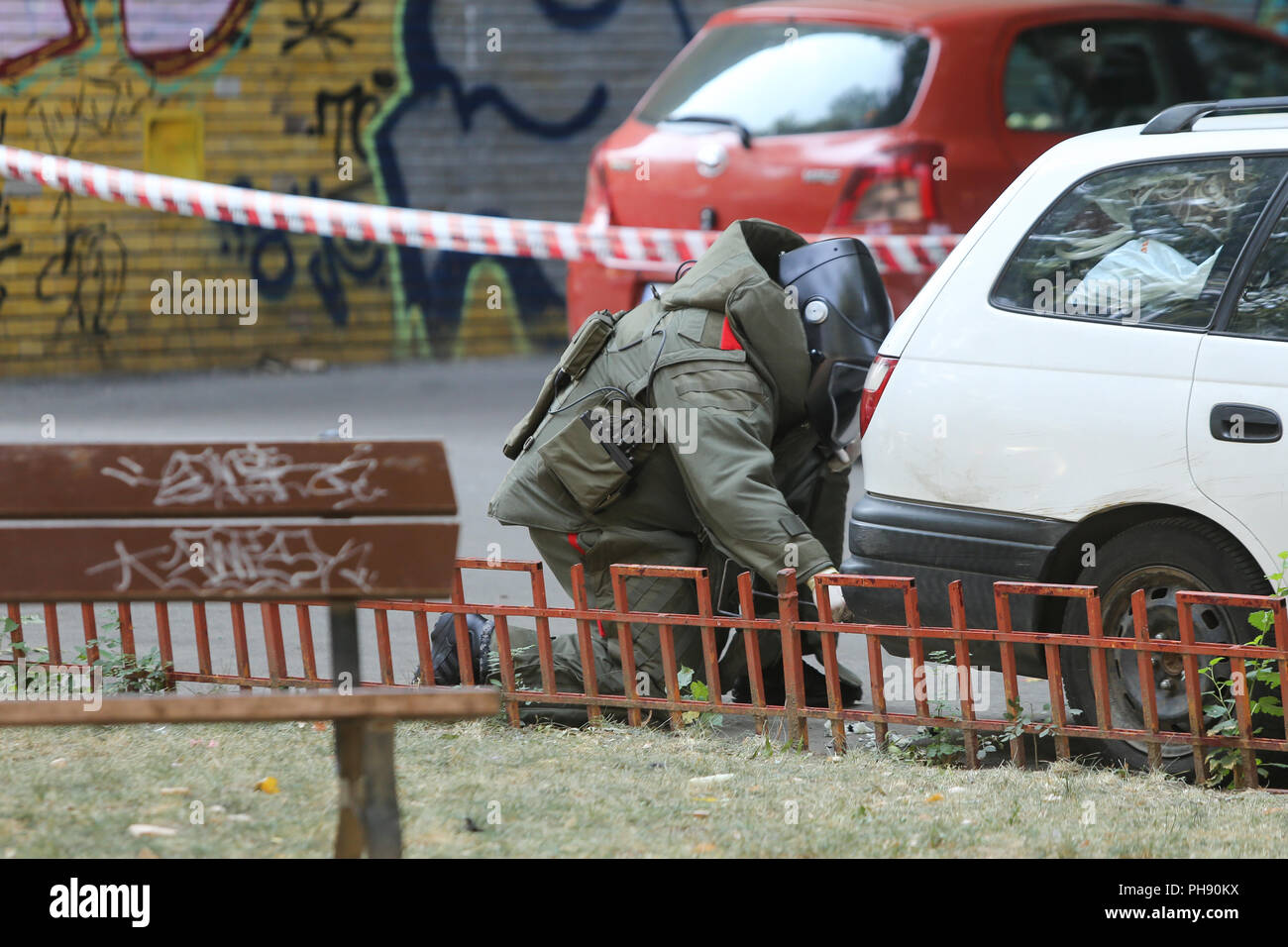 Bucarest, Roumanie - 31 août 2018 : Artificier en combinaison antibombe pour l'élimination des explosifs et munitions (NEM) est la vérification d'une voiture suspecte dans une rue je Banque D'Images