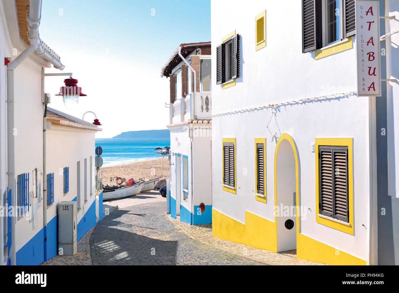 Petite ruelle romantique aux maisons colorées menant à une plage de sable fin avec bateau de pêche et sur la mer Banque D'Images