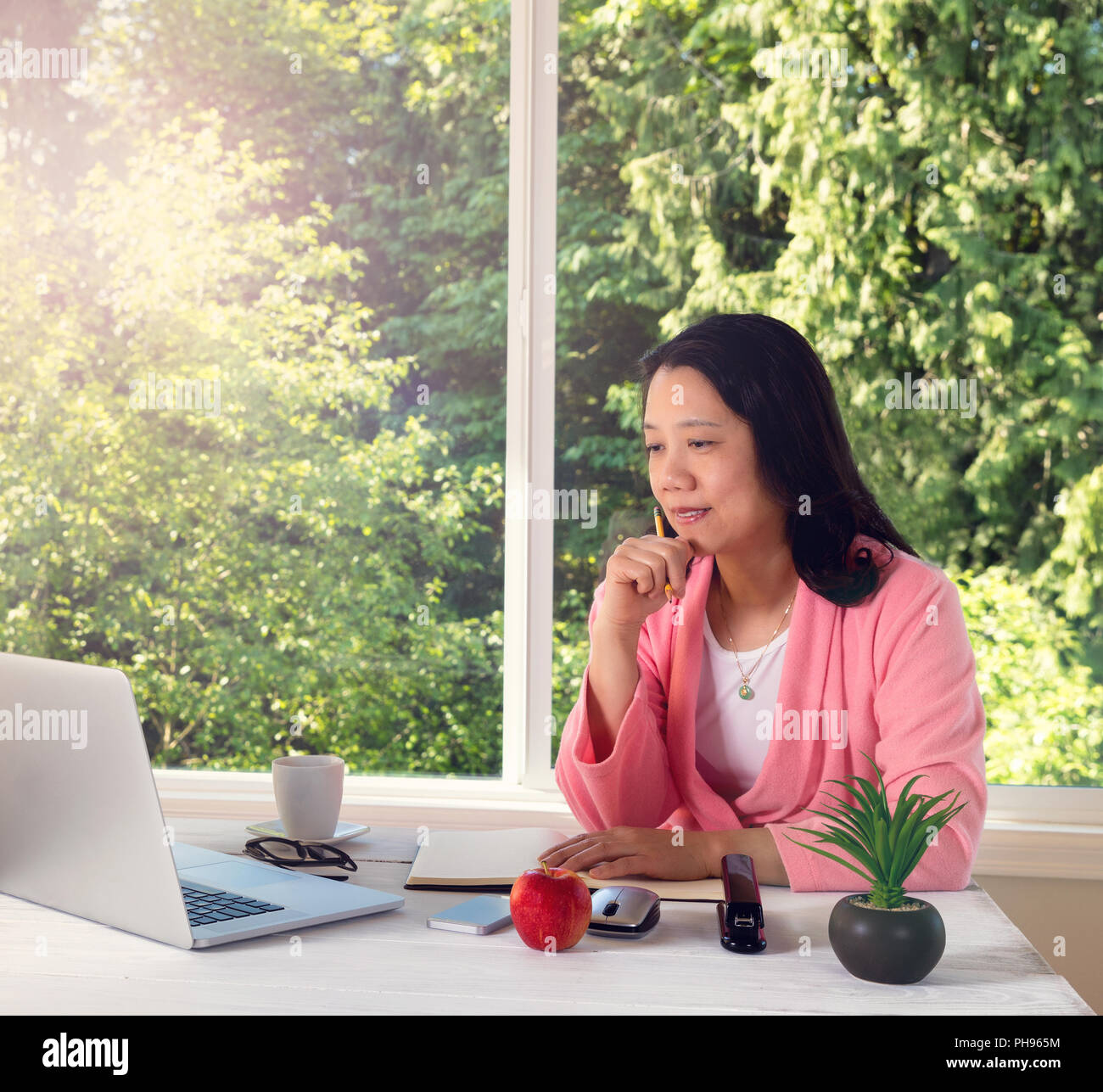 Mature Woman enjoying matin léger tout en travaillant à la maison Banque D'Images