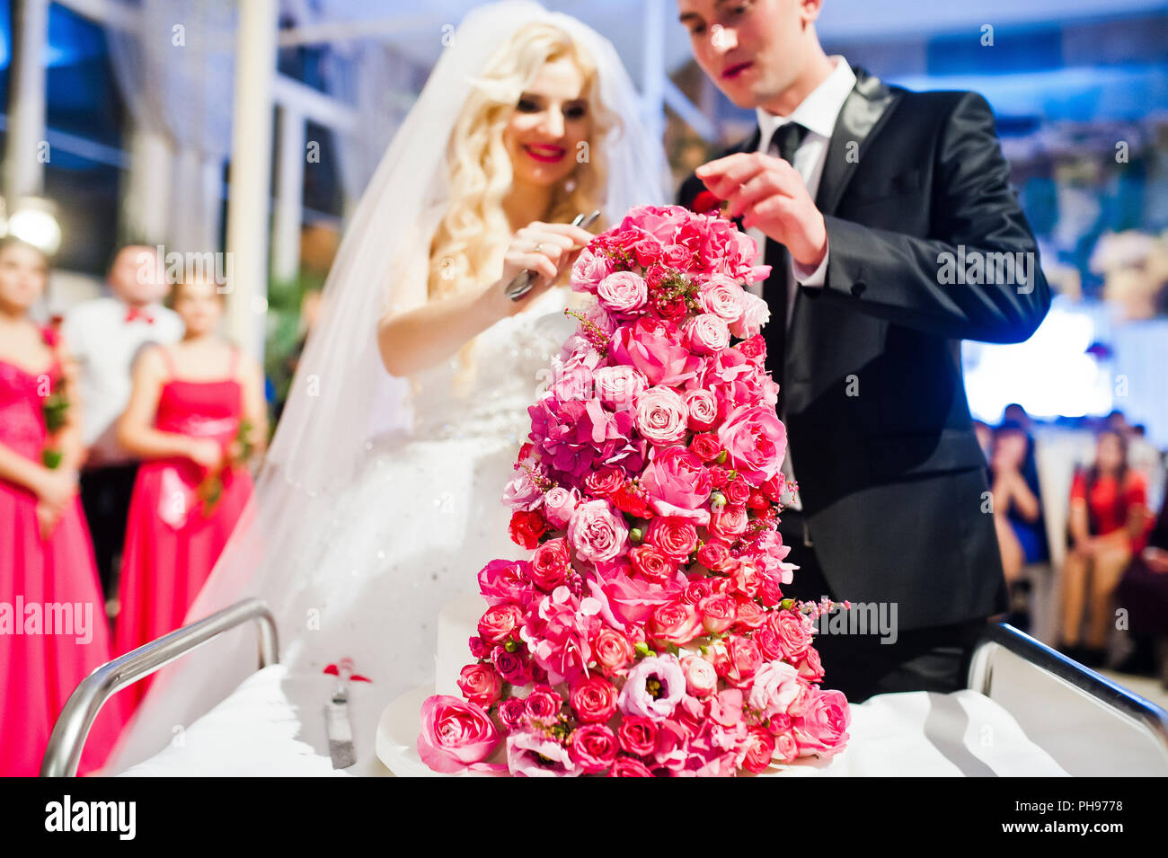 Wedding couple avec sweet gâteau de mariage avec des roses rose Banque D'Images