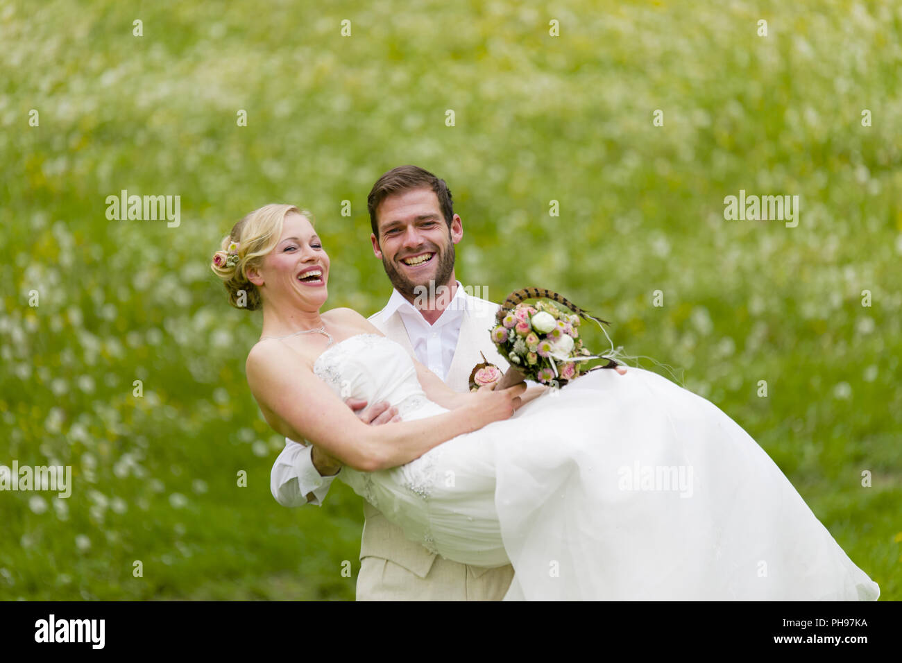 Mariage jardin groom transportant son épouse Banque D'Images