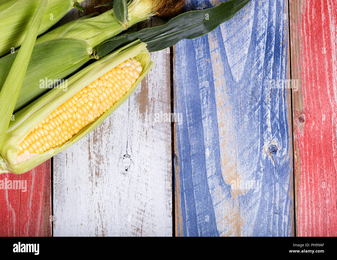 Le maïs frais sur les conseils rustique peint en couleurs nationales USA Banque D'Images