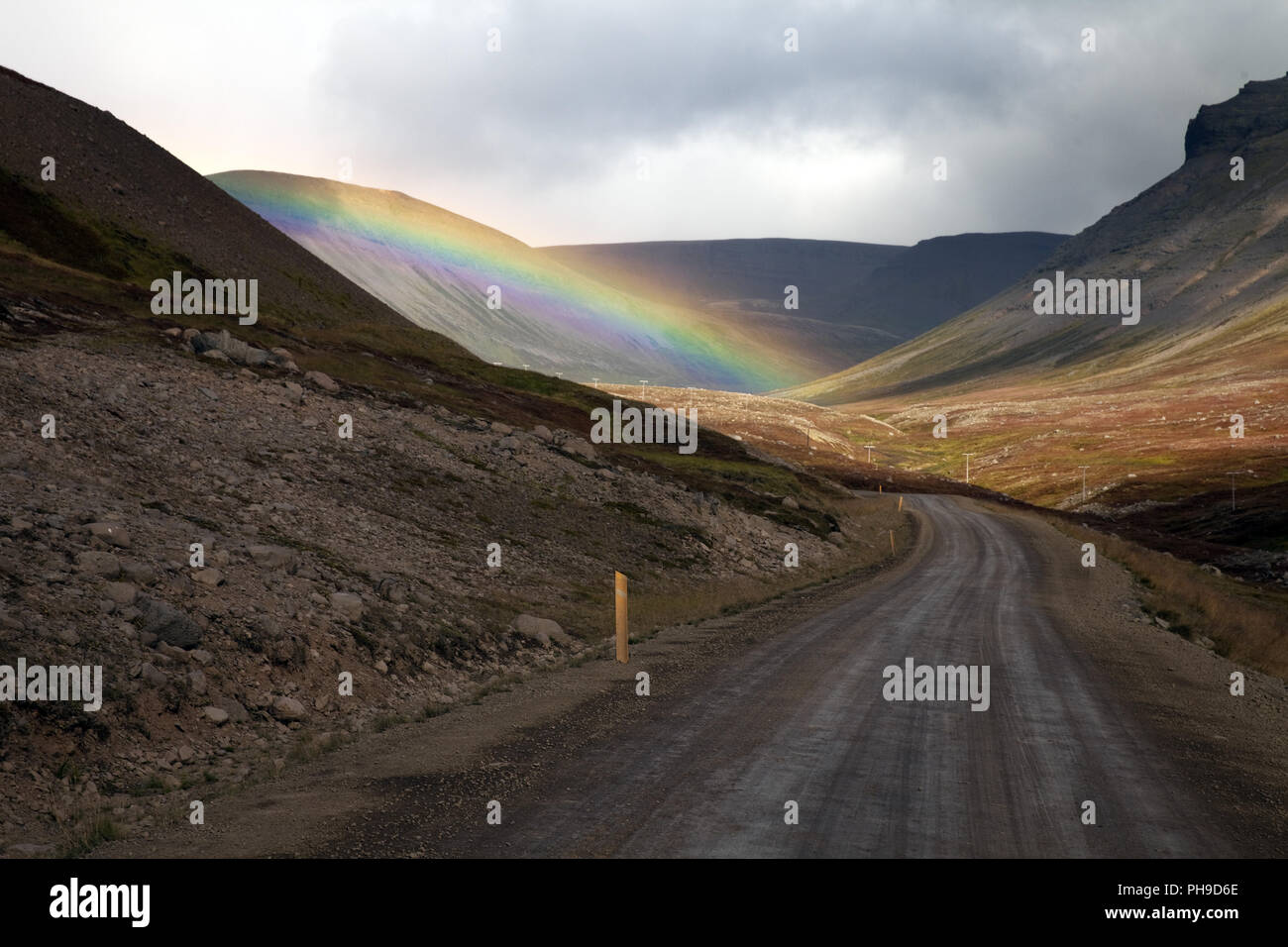 Rainbow au-dessus d'une route dans les montagnes, Westfjorde, Islande Banque D'Images