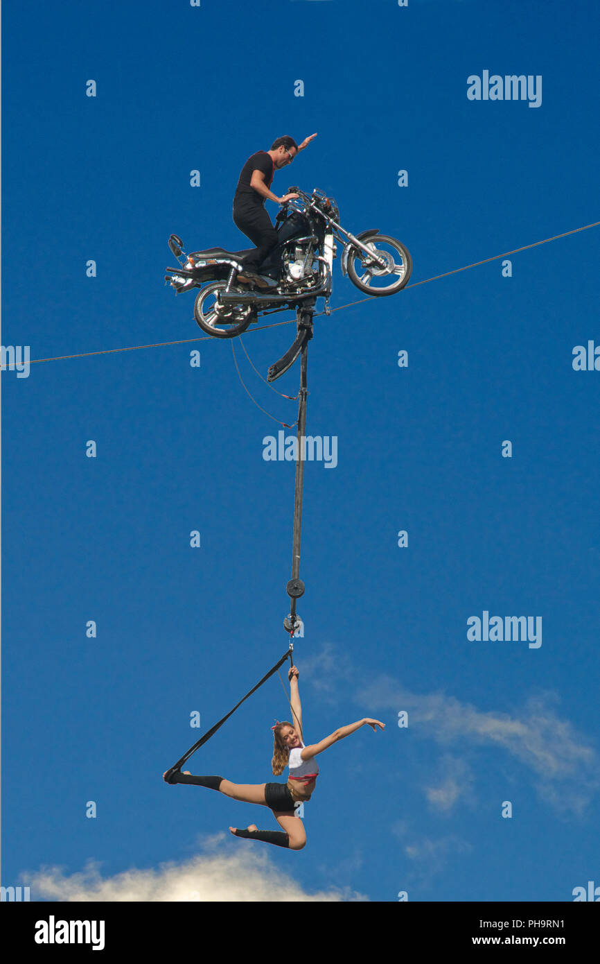 Moto stunt rider sur fil avec girl acrobat Albert Park Melbourne Australie Victoria Banque D'Images