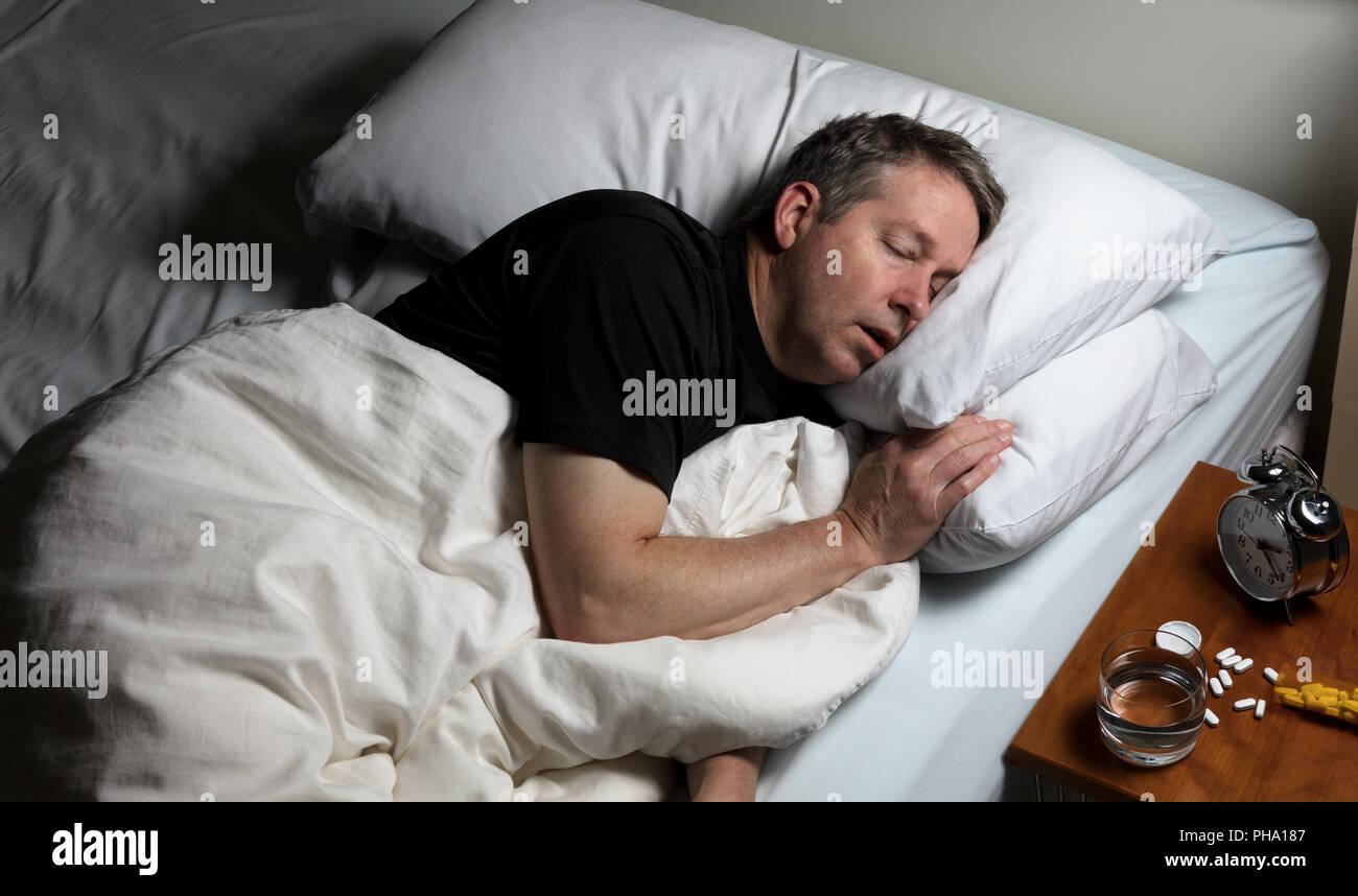 Homme mûr d'essayer de s'endormir après avoir pris des médicaments Banque D'Images