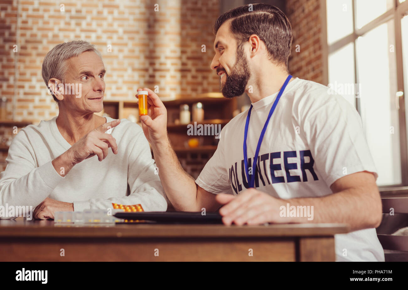 De curieux homme pointant à pilules et d'avoir une conversation. Banque D'Images