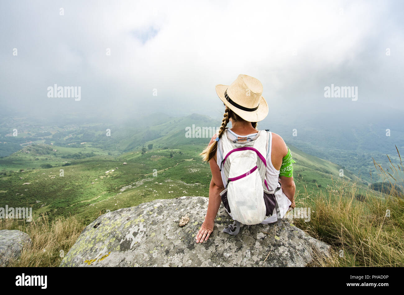 Travel concept : jeune fille de touriste avec un sac à dos assise sur le bord d'une falaise. Copier l'espace. Banque D'Images