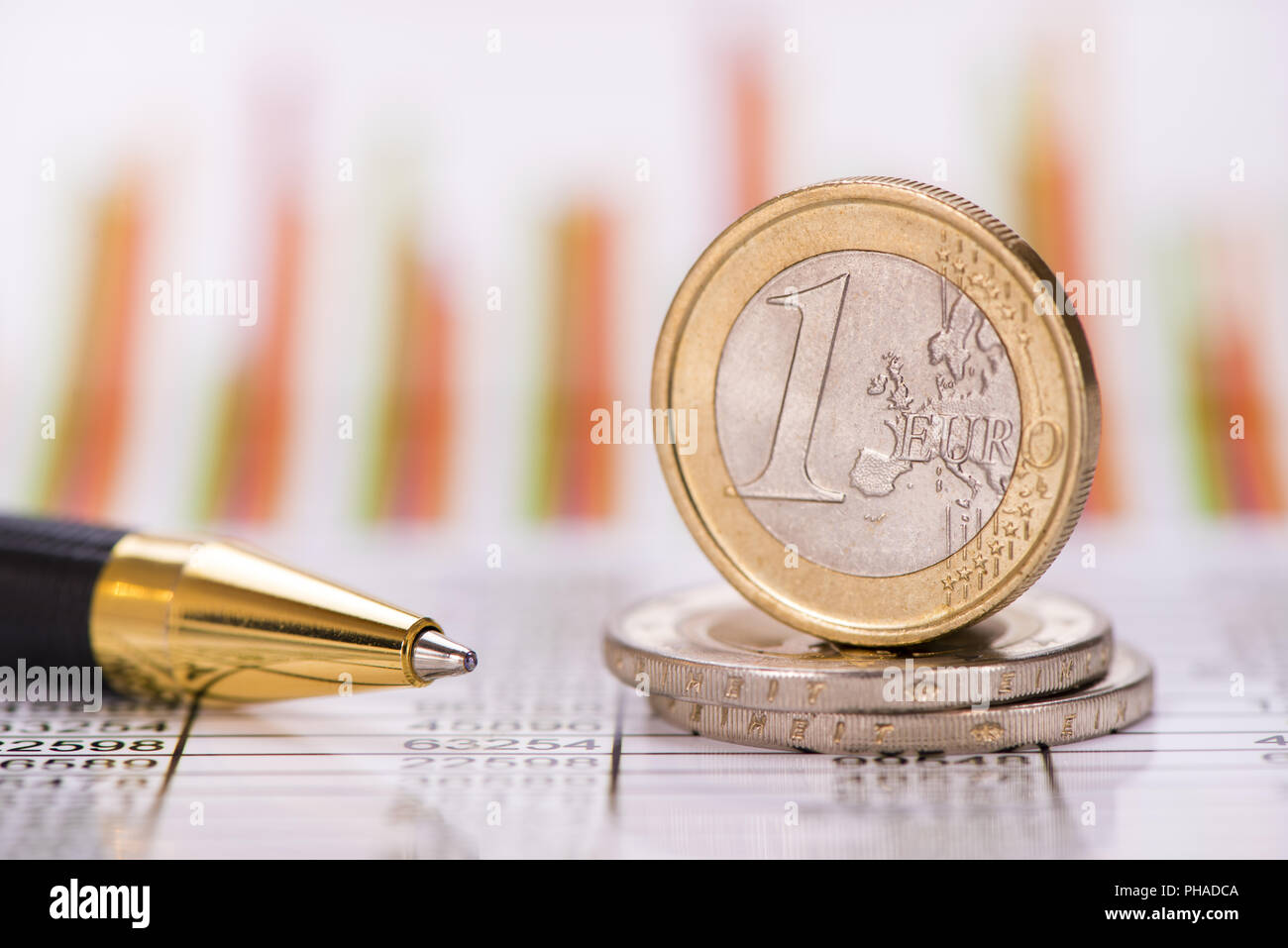 Les pièces en euros empilés avec des données et tableau des marchés de change Banque D'Images