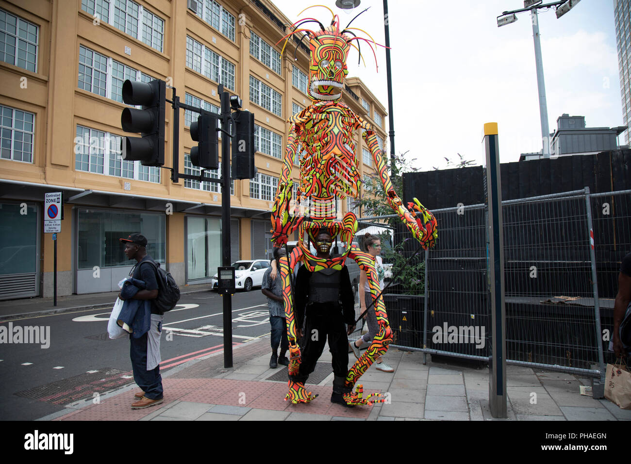 Tenue d'une étrange marionnette marche géant porté par certains artistes de rue, d'une troupe de Samba à Londres, Royaume-Uni. Banque D'Images