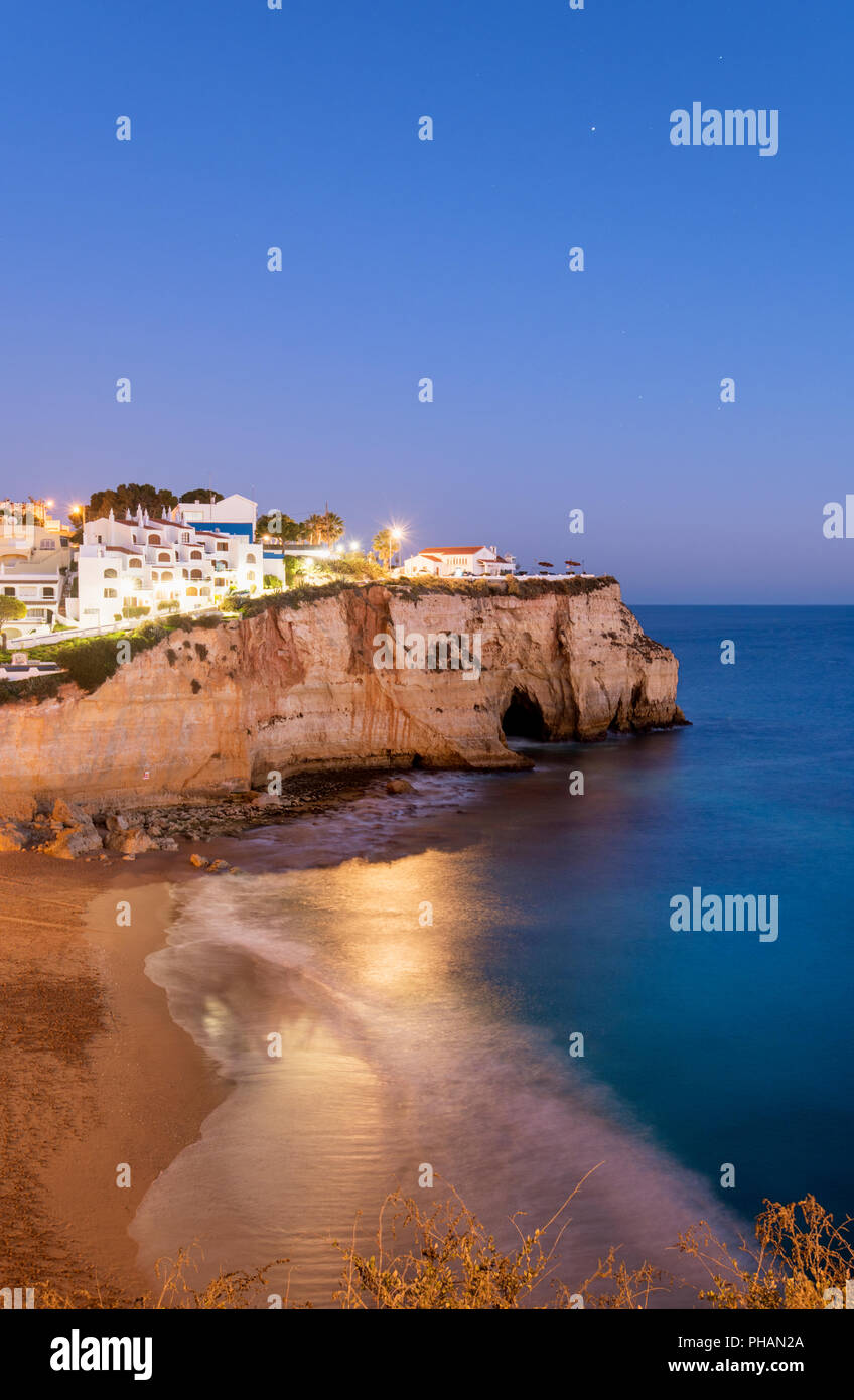 La plage et le village de Carvoeiro au crépuscule. Lagoa, Algarve, Portugal Banque D'Images