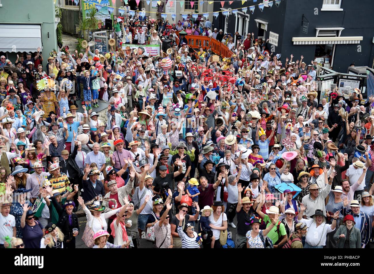Bridport Hat Festival, Dorset, UK Bridport Hat Festival est une célébration de chapeaux, une levée de fonds pour les organismes de bienfaisance liés à la tête et un géant de l'été se terminant à partie de la ville et des visiteurs - sont toutes dirigées par des bénévoles. Le plus créatif et original, élégant et inventif coiffure combine avec de la musique live, de multiples concours, démonstrations, conférences, expositions, spectacles, un chapeau, des jeux d'enchères, et tous les chiens casquette 'Arrêté' par une énorme masse hat à l'usure en photoshoot Doo Bucky Square sur 'Haturday'. Finnbarr Crédit : Webster/Alamy Live News Banque D'Images