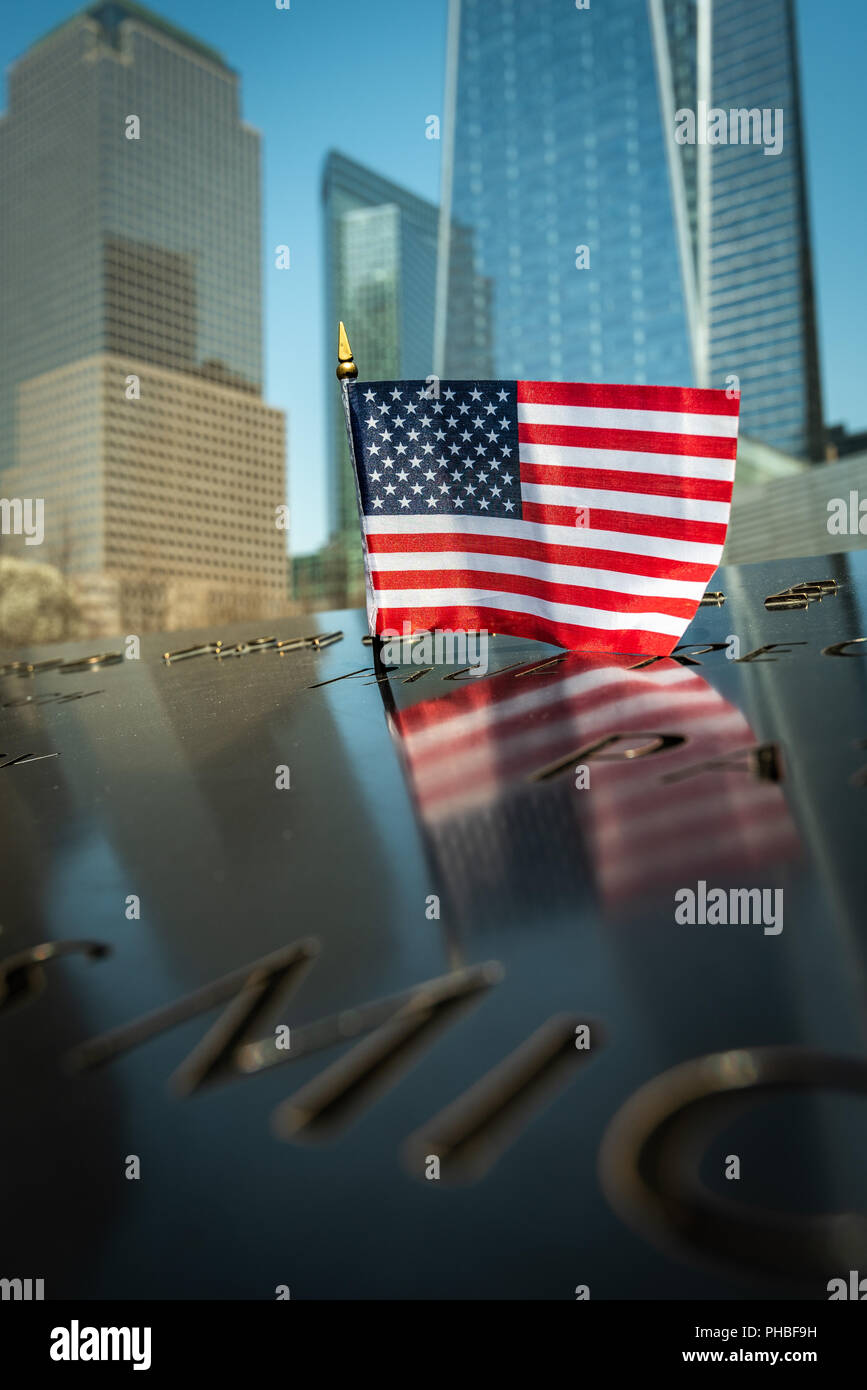 Un petit drapeau américain à la 9/11 Memorial Park à New York avec le nouveau World Trade Center à la hausse dans l'arrière-plan, New York, USA Banque D'Images