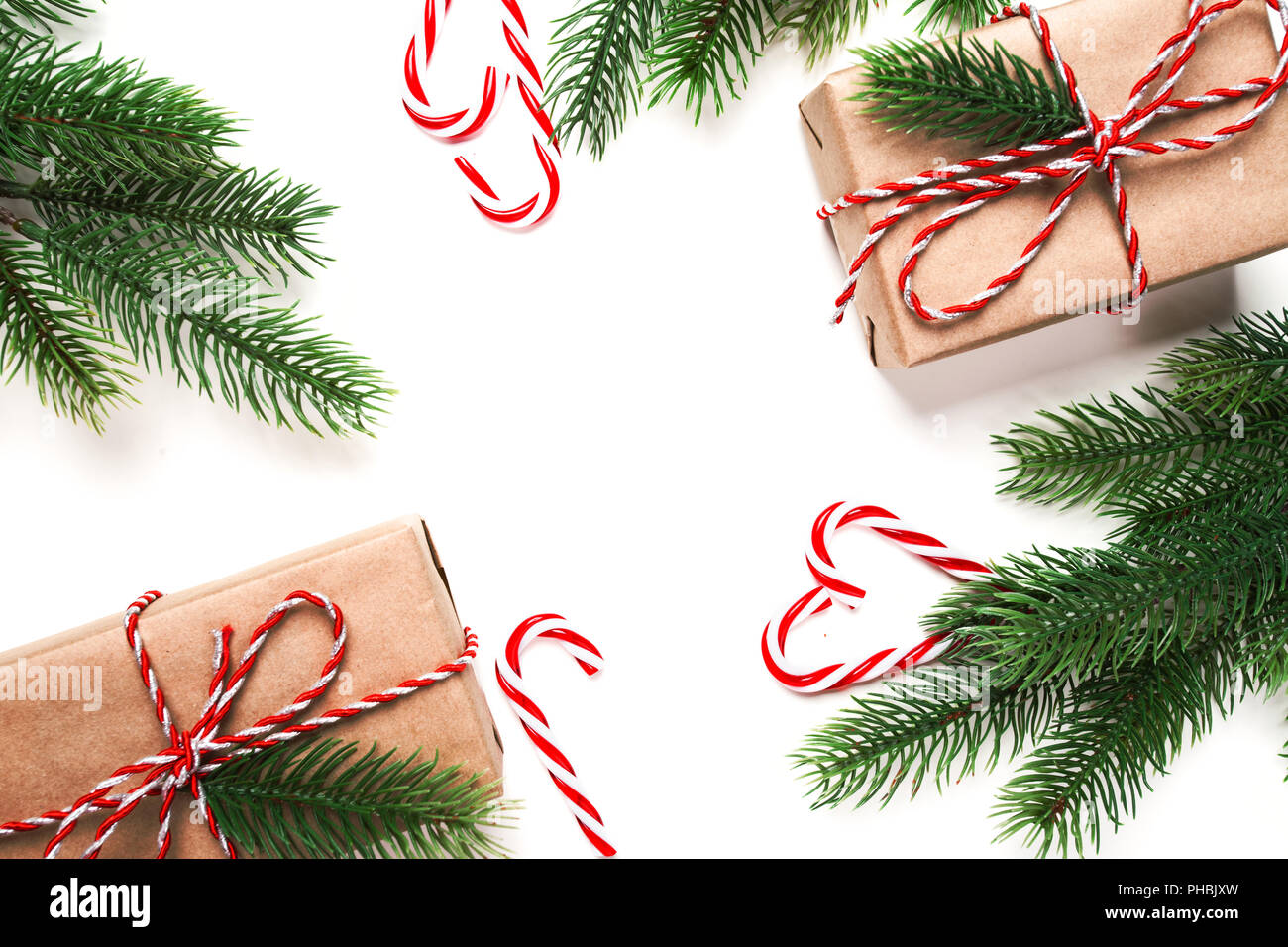 Composition de Noël. Cadeaux de Noël, branches de sapins, des bonbons sur fond blanc Banque D'Images