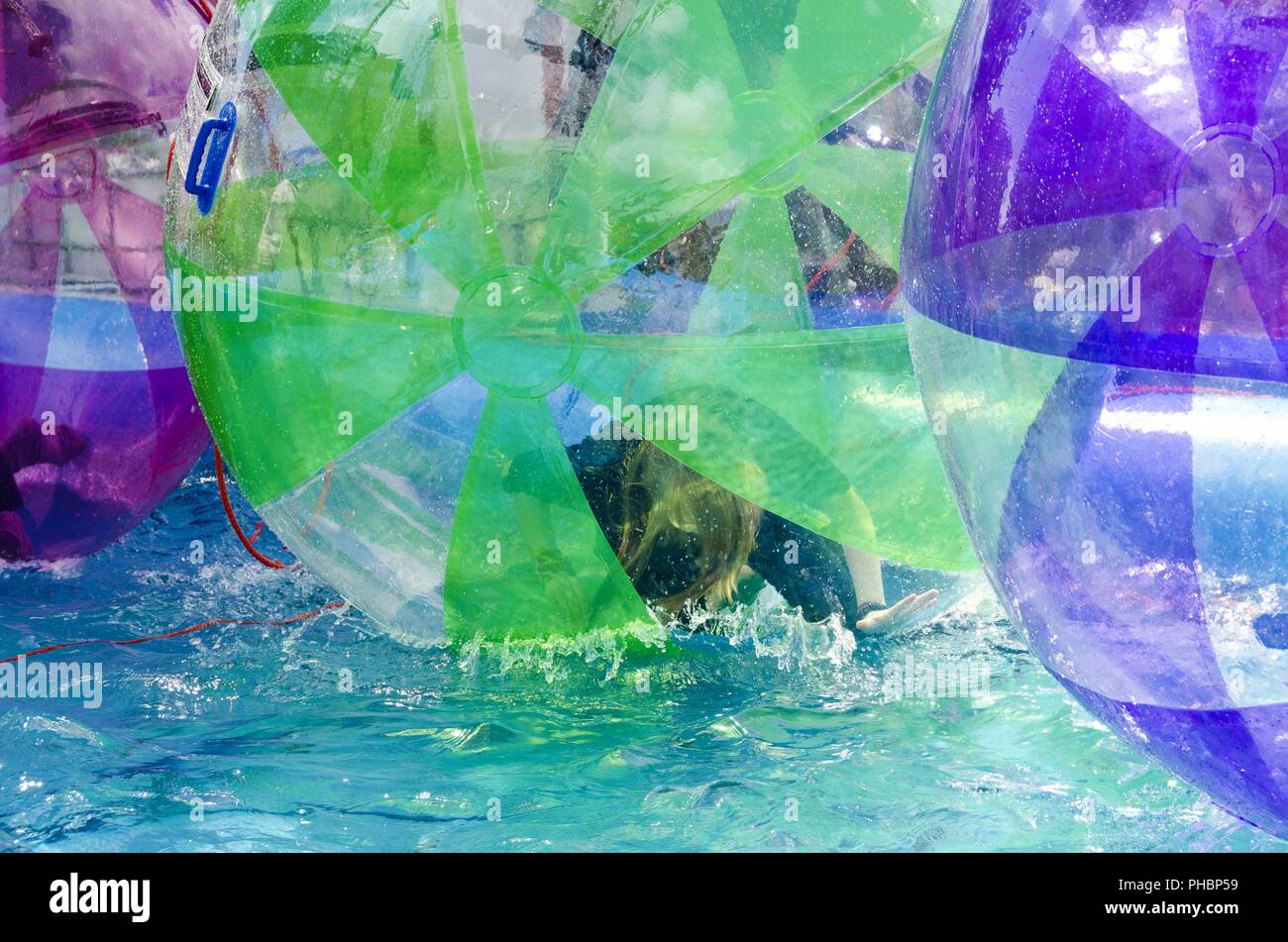 Femme dans un orbe en plastique sur l'eau Banque D'Images