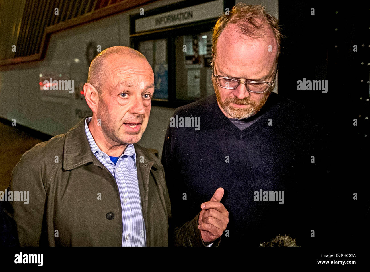 Des journalistes d'enquête Barry McCaffrey (à gauche) et Trevor Birney (droite) à l'extérieur de Musgrave Street station de police de Belfast. Banque D'Images