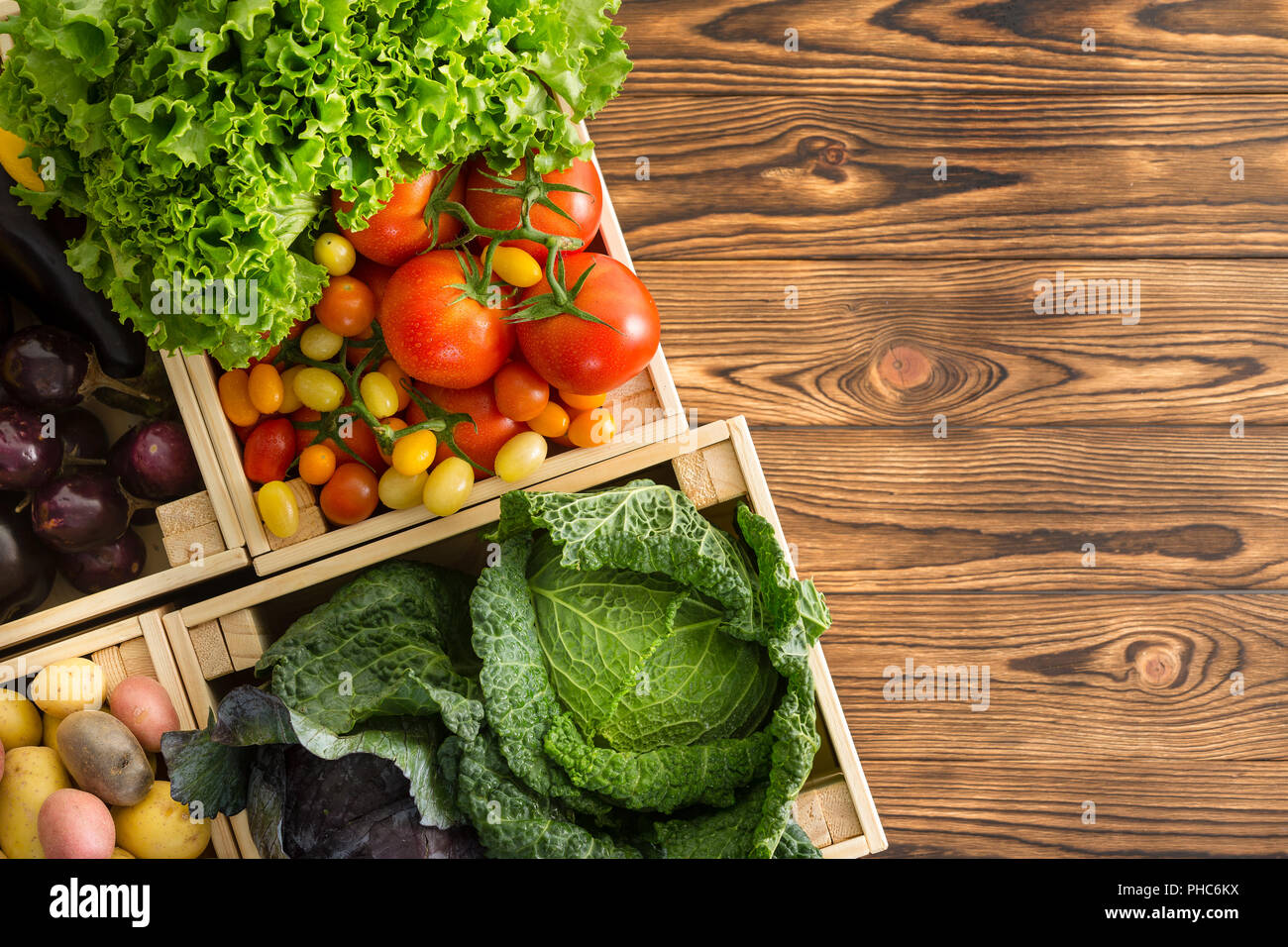 Variété de légumes frais et sain dans les cases affichées sur une table en bois table en bois à un marché de producteurs biologiques Vue descendante avec copie espace Banque D'Images