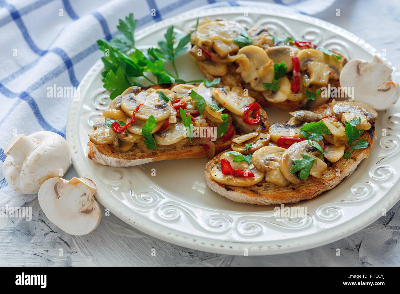 Le ciabatta avec champignons et oignons sur une assiette blanche. Banque D'Images