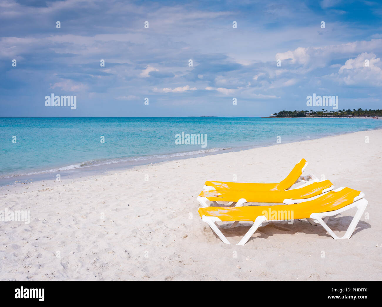 Chaises de salon jaune vif sur la plage de sable blanc à côté de l'océan clair à Varadero, Cuba. Banque D'Images