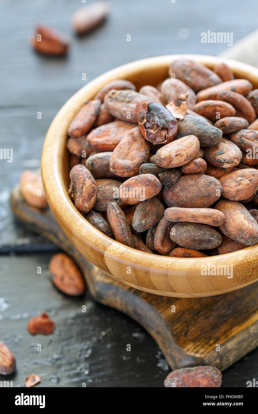 Les fèves de cacao dans un bol en bois. Banque D'Images
