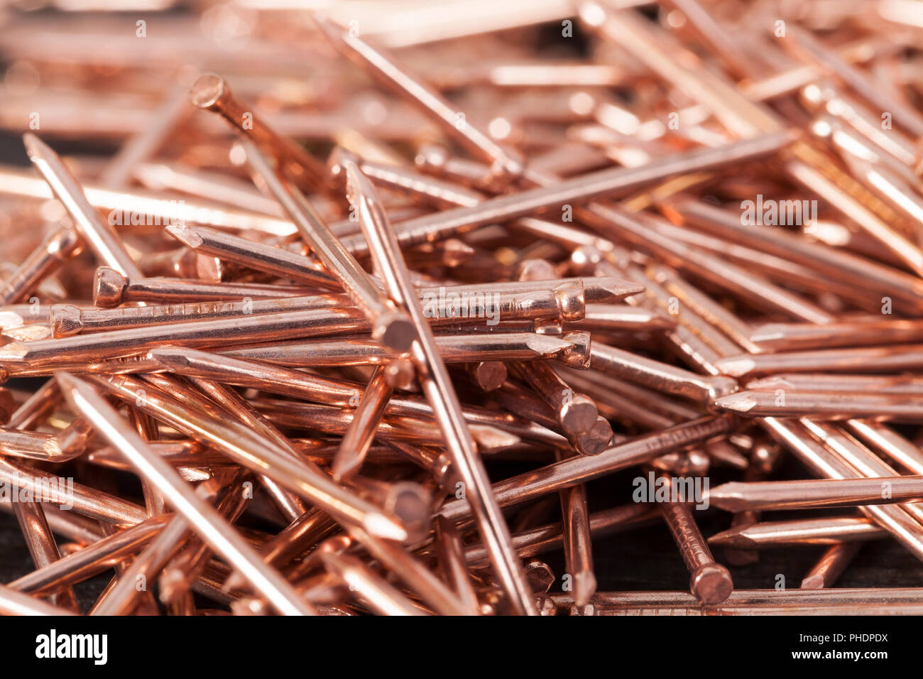 Des clous à finir en cuivre couché dans une pile, close-up des matériaux métalliques utilisés dans la construction Banque D'Images