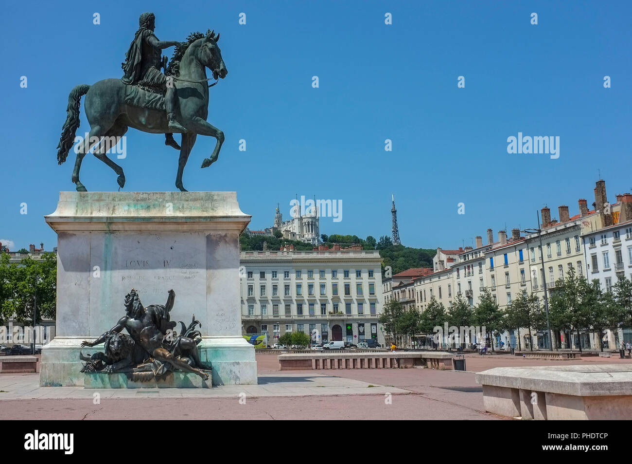 Statue équestre de Louis XIV sur la Place Bellecour avec la Basilique de Notre-Dame de Fourvière à l'arrière-plan sur la colline, à Lyon en France. Banque D'Images
