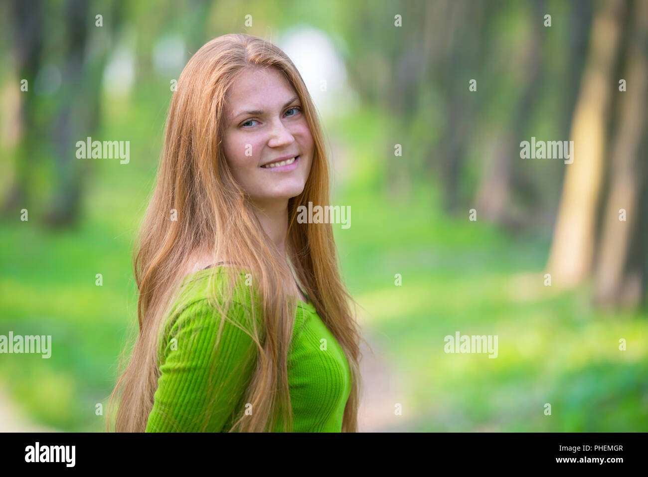 Jolie femme aux cheveux rouges dans le parc Banque D'Images