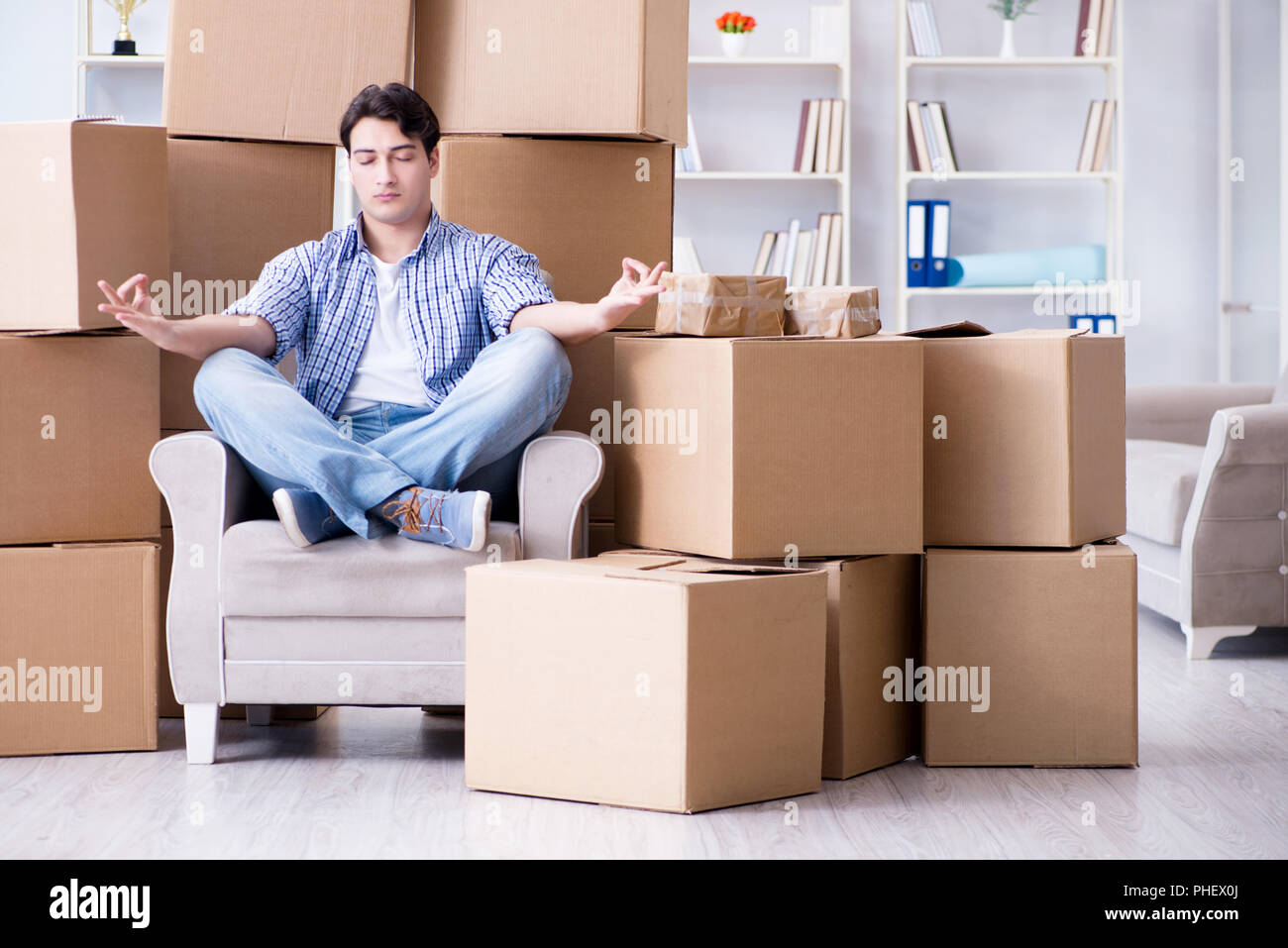 Jeune homme déménagement dans de nouvelles boîtes avec chambre Banque D'Images