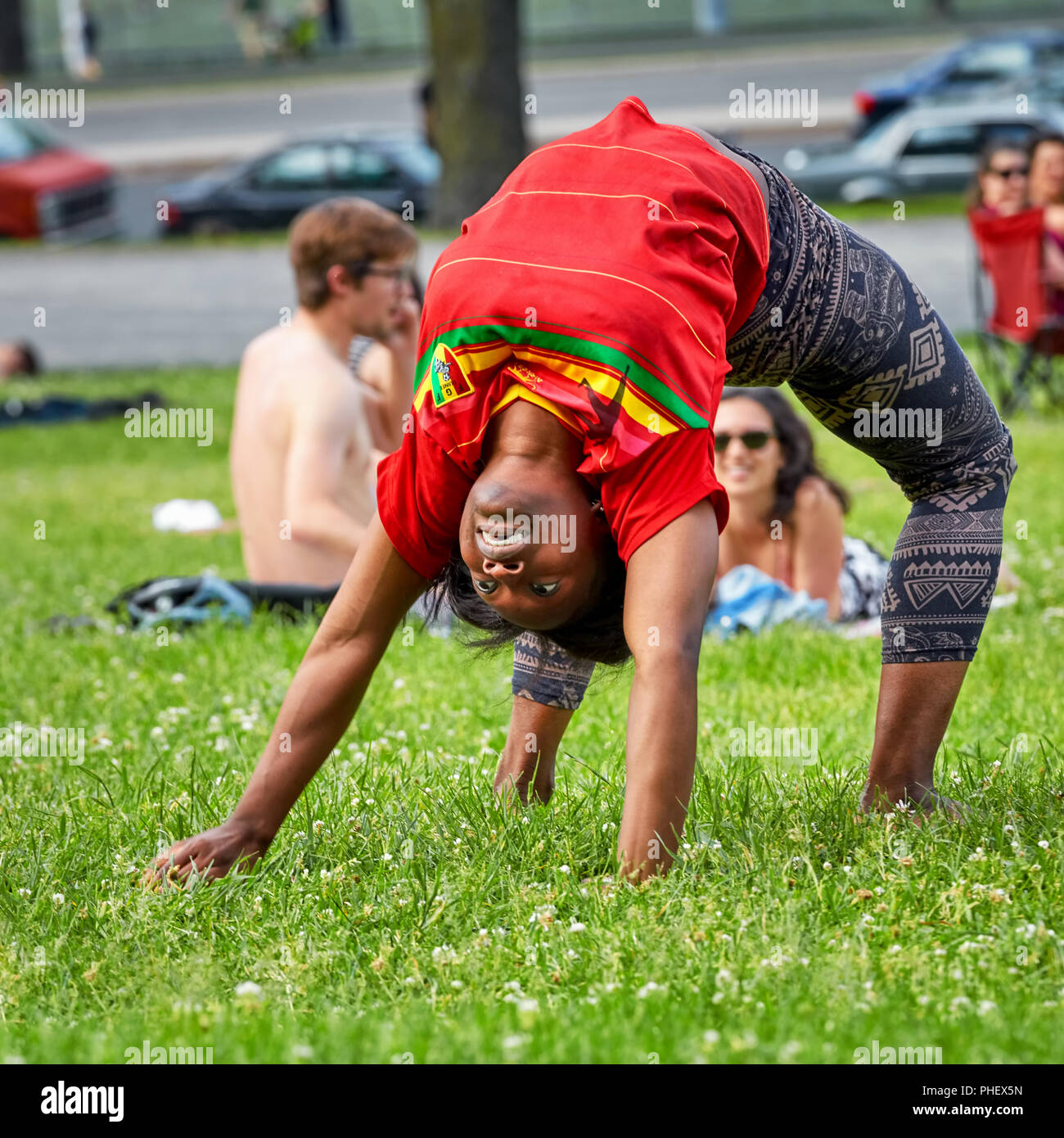 Les jeunes et les femmes afro-américaines élastique fait un pont arrière se déplacent sur le tronçon de l'herbe du parc du Mont-Royal à Montréal, Québec, Canada. Banque D'Images