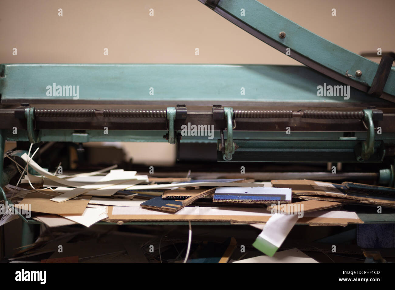 Grande guillotine pour couper du papier avec la lame posée dans un angle faible vue rapprochée sur la table de travail en désordre Banque D'Images