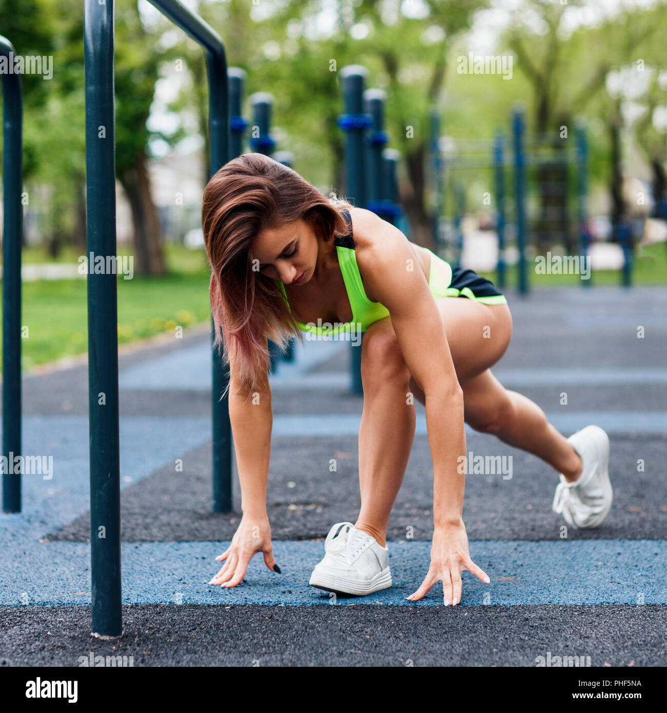 Femme sportive avec perfect athletic body qui s'étend dans le parc. Banque D'Images