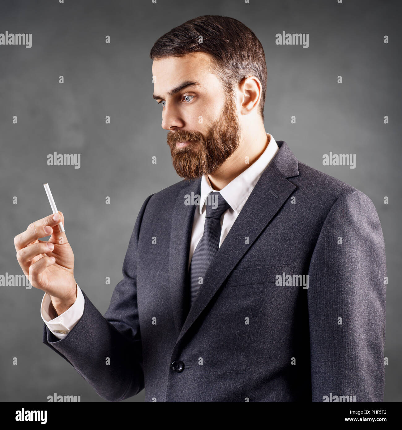 Abasourdi businessman looking on cigarette dans la main. Banque D'Images