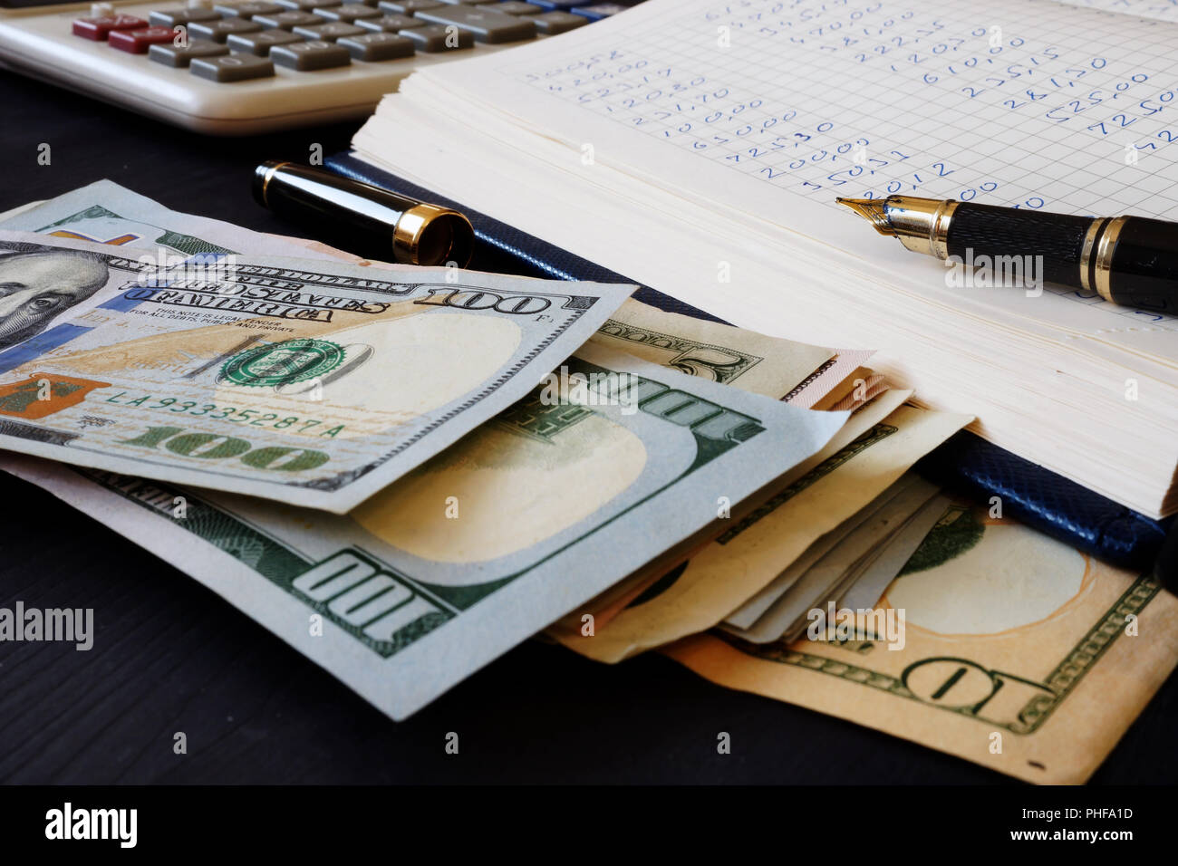 Ledger, calculatrice et billets en dollars. Tenue de livres. Banque D'Images