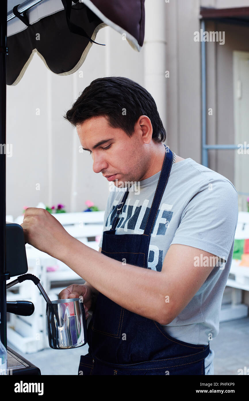 Verser dans la tasse de lait Barista Banque D'Images