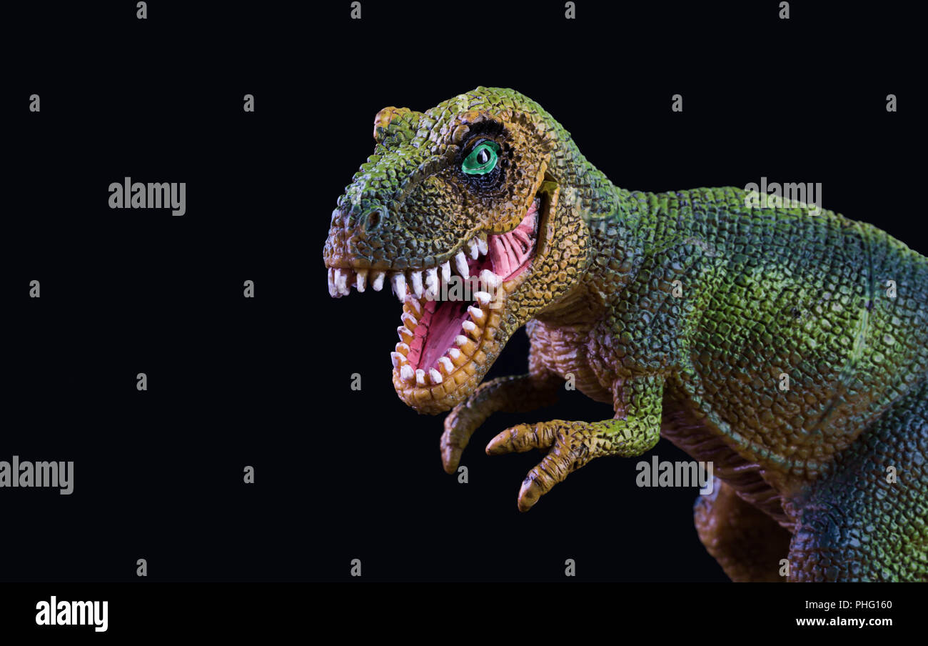 Jouet dinosaure en plastique isolé sur fond noir Banque D'Images