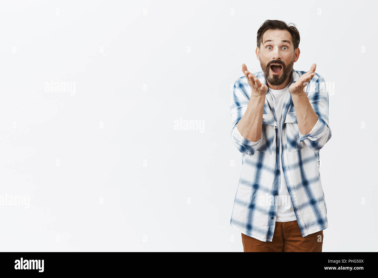 Guy regarder le soccer, ne peux pas croire qu'équipe favorite perdre, l'humiliation de la partition. Bien nerveuse intense mari avec barbe, se serrer la main et à regarder l'appareil photo, posant sur fond gris Banque D'Images