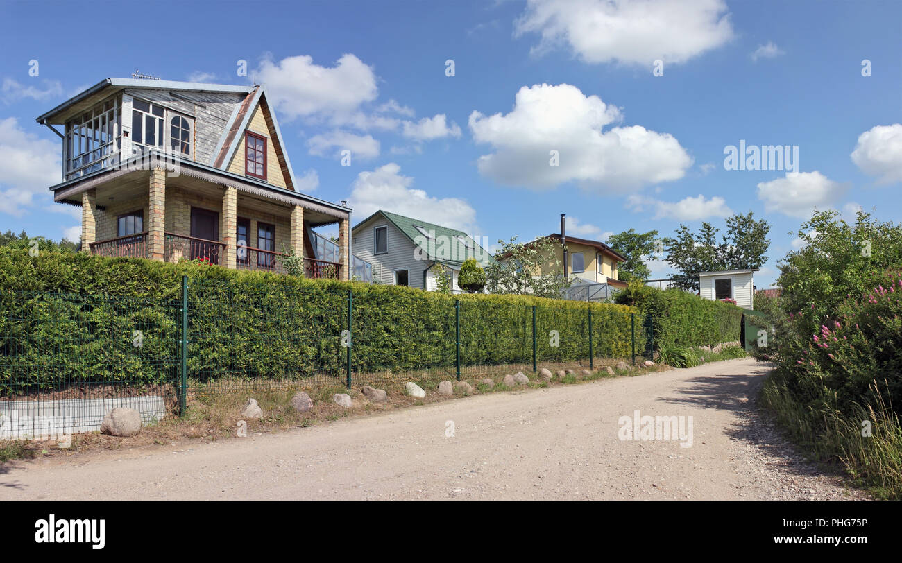 Style rustique cottages derrière une barrière verte Banque D'Images