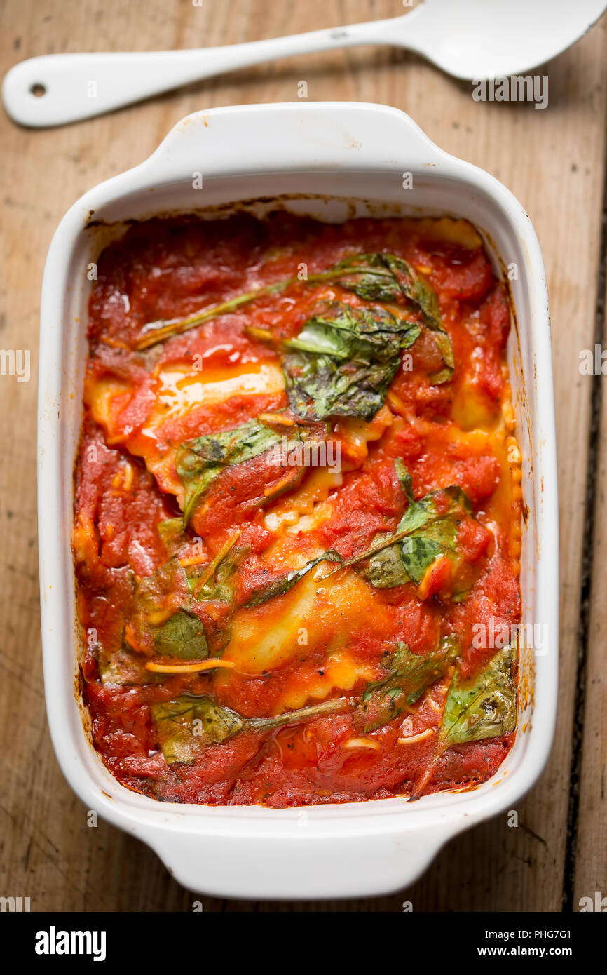 Raviolis à la sauce tomate avec les feuilles d'épinards Banque D'Images