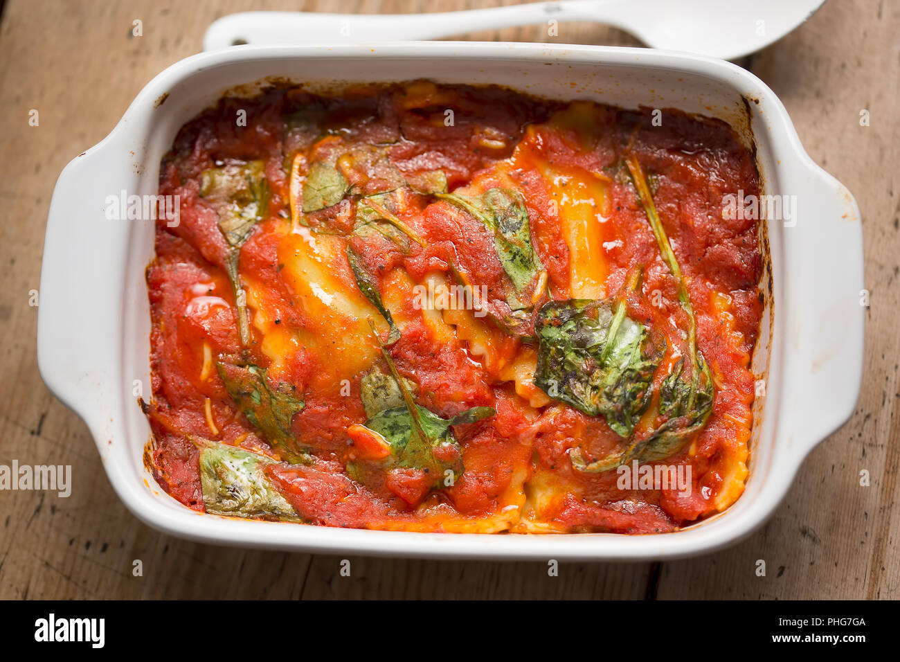 Raviolis à la sauce tomate avec les feuilles d'épinards Banque D'Images