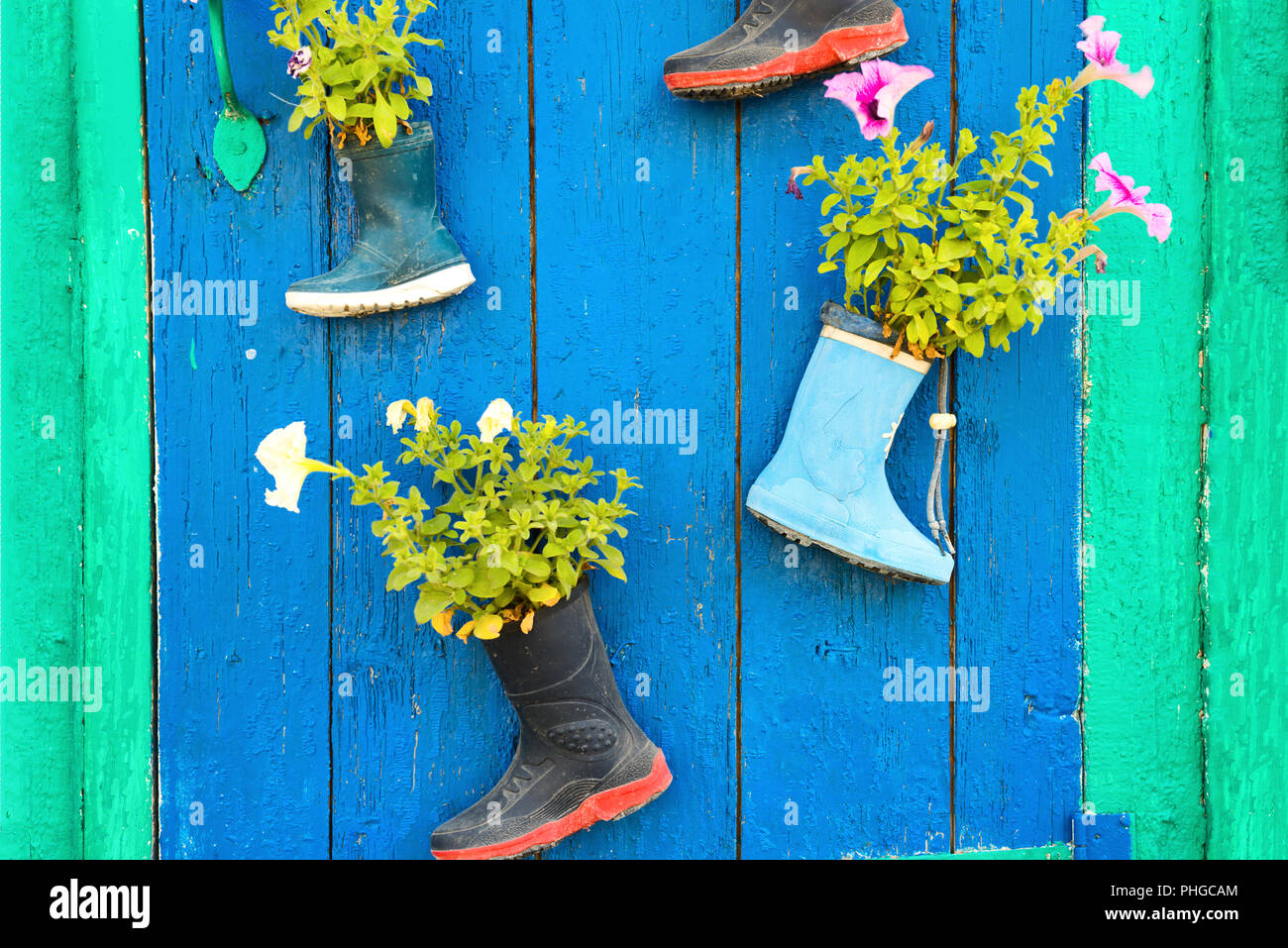 Vieilles bottes en caoutchouc avec des fleurs Banque D'Images