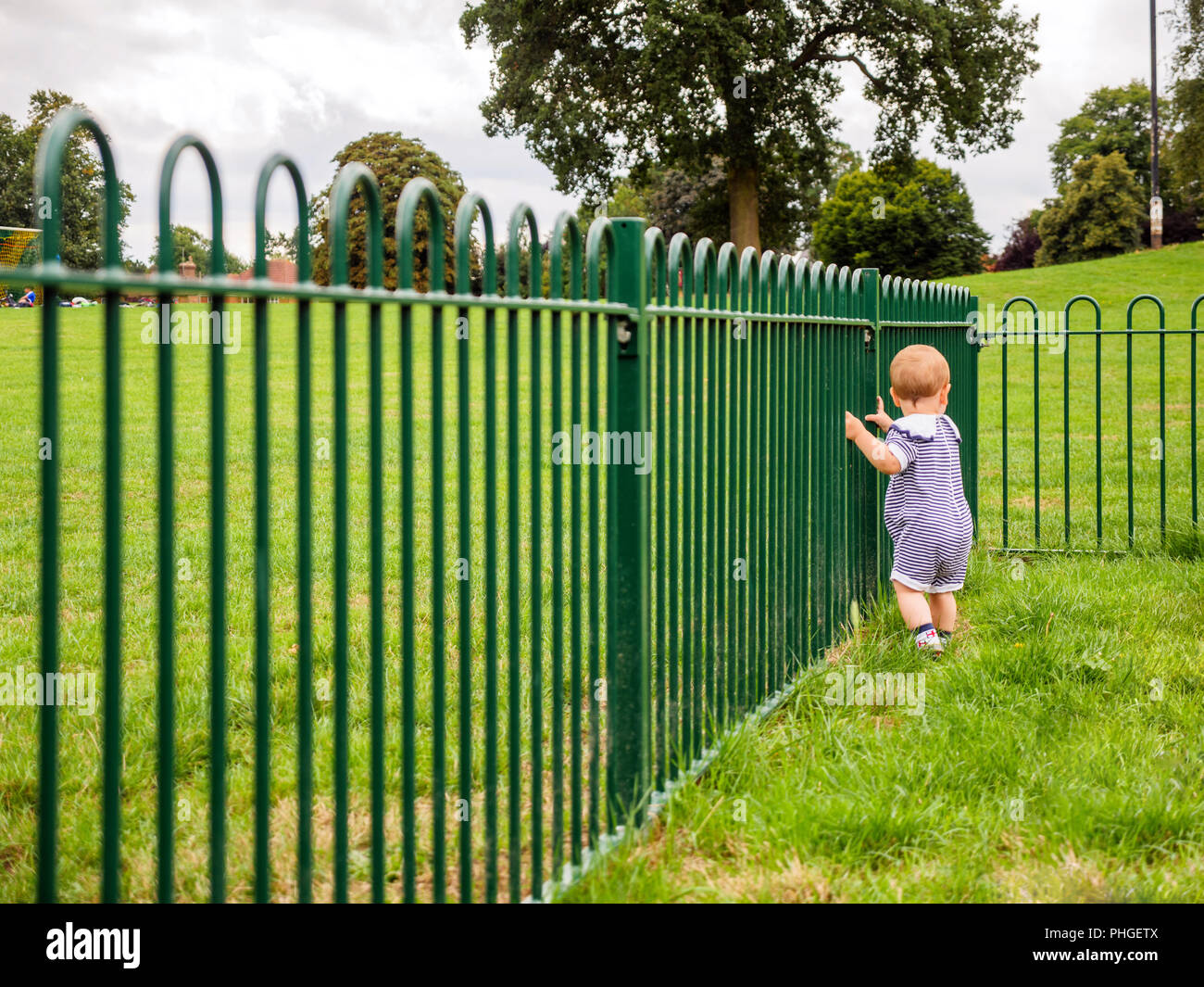 Bebe Garcon En Bleu A Cote De Costume De Marin Pour Cloture Verte Dans Les Jeux Pour Enfants Photo Stock Alamy