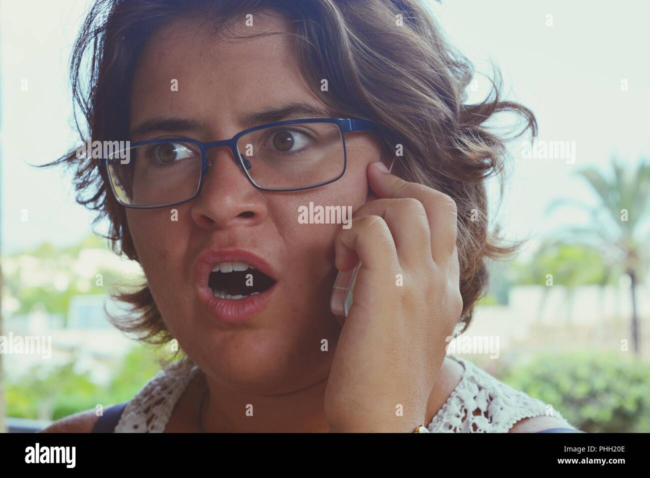 Woman using cellphone millénaire, à choqué et scandalisé. Banque D'Images