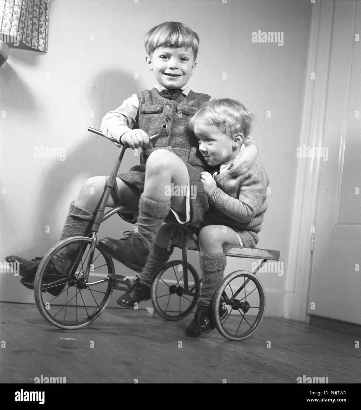 1940 enfants. Deux garçons jouent sur un tricycle. Le frère aîné, il pédale et le jeune frère est assis à l'arrière. Suède 1944. Kristoffersson Photo ref M122-6 Banque D'Images