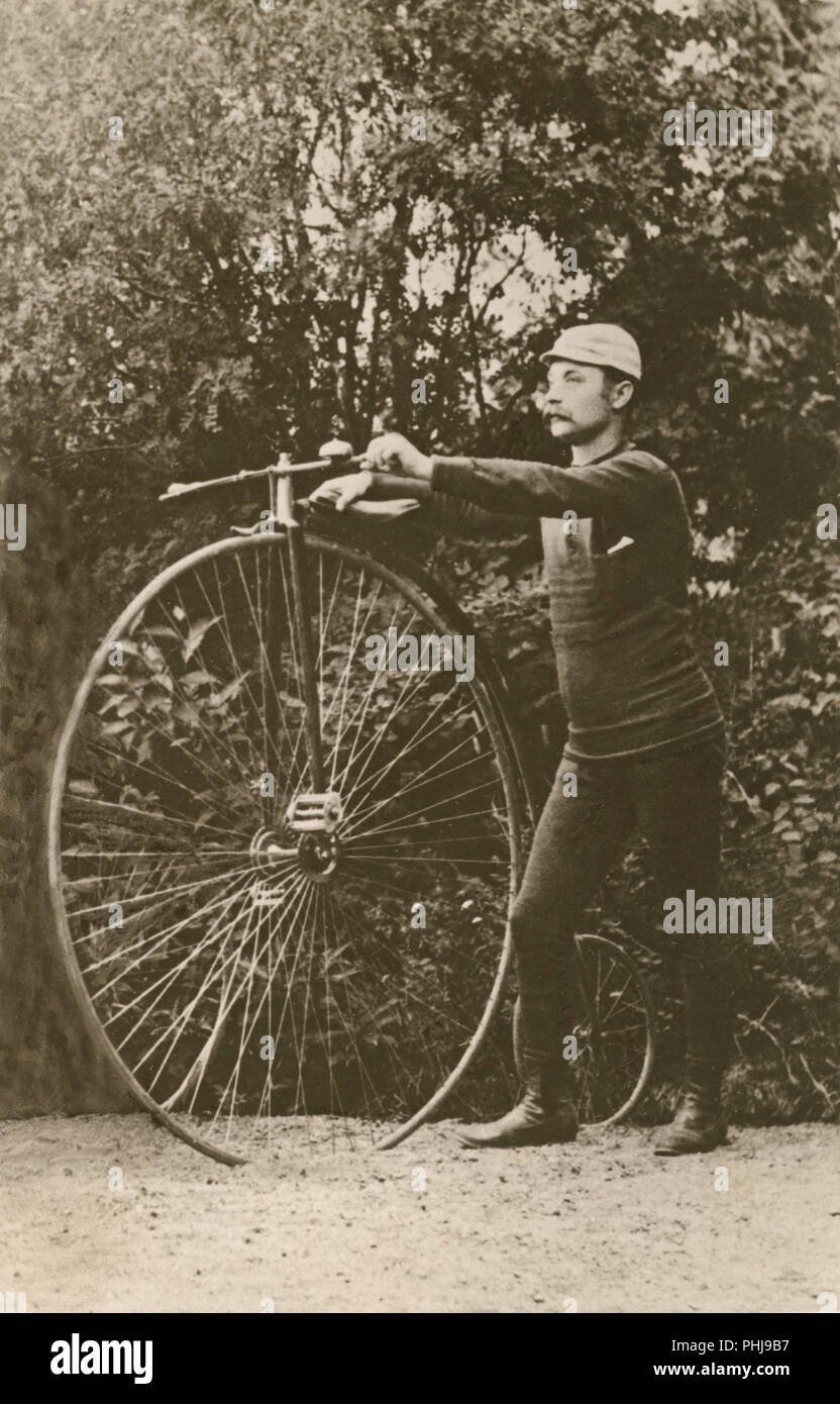 Penny Farthing location. Un homme est debout à côté d'un penny farthing-vélo.  Un bicycycle modèle avec une grande roue avant et une petite roue arrière.  Suède 1880 Photo Stock - Alamy