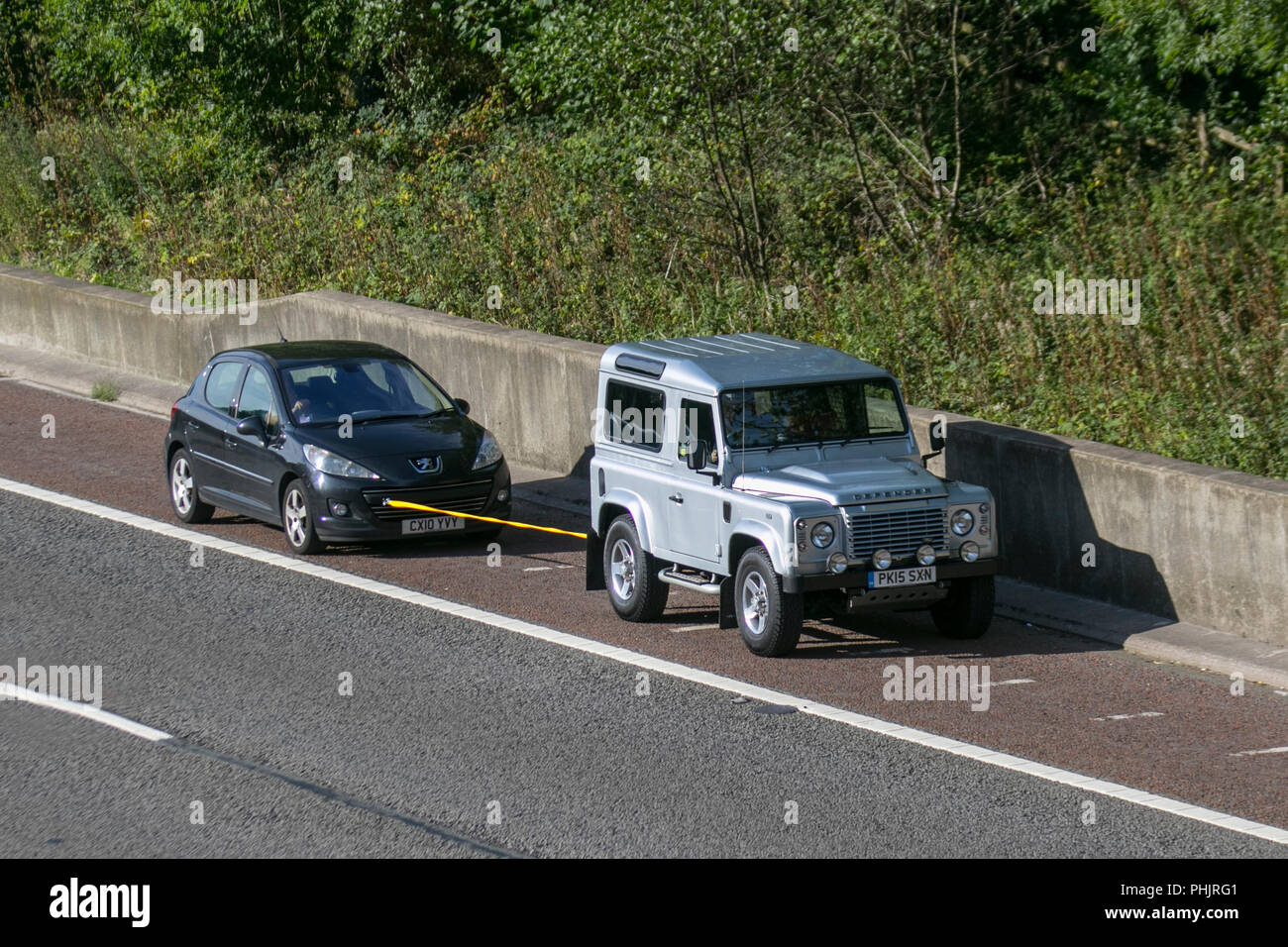 SWB Land Rover Defender remorque un autre véhicule avec une corde, sur la bande d'arrêt d'urgence, de loisirs, hors route, de sauvetage, de récupération du véhicule véhicule robuste, UK Banque D'Images