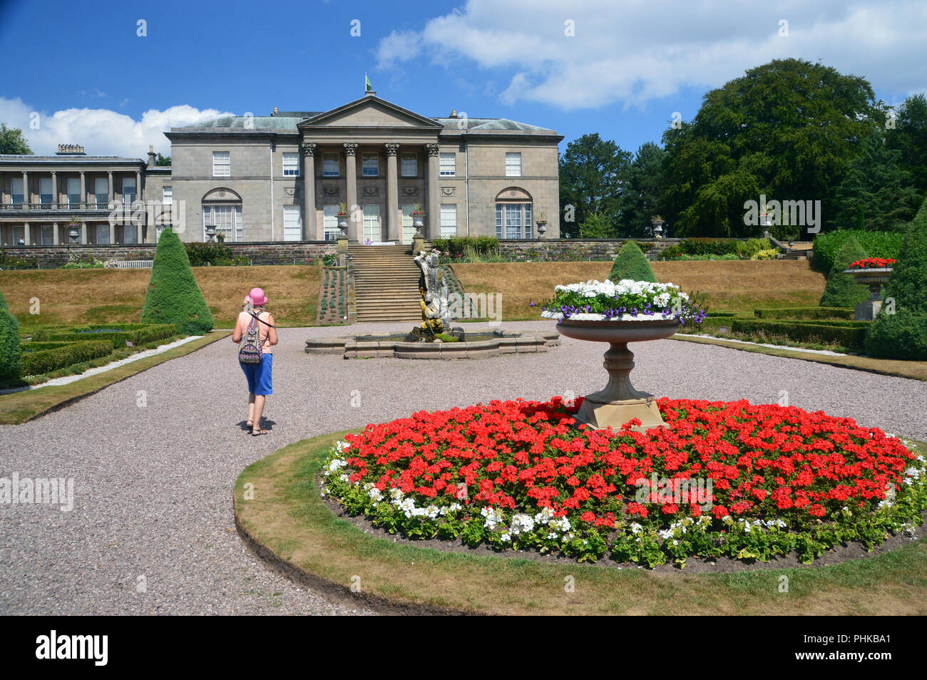 Une femme marche dans le jardin à l'Italienne à la Mansion House dans le parc Tatton, Knutsford, Cheshire, Angleterre, Royaume-Uni. Banque D'Images