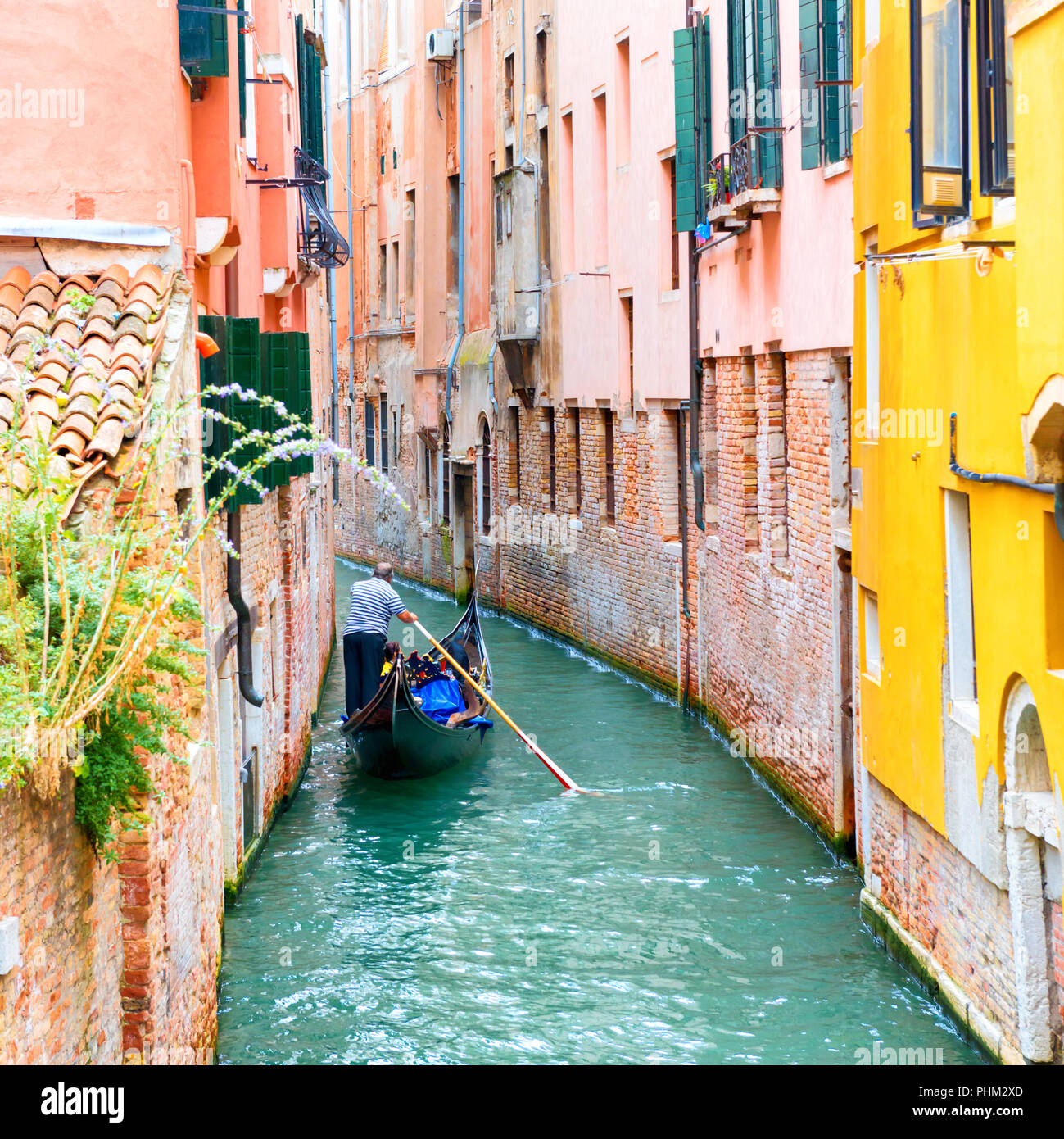 Gondolier sur un canal à Venise Banque D'Images