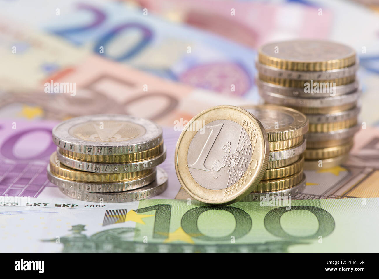 Beaucoup de billets de monnaie européenne fixant sous pièces empilées Banque D'Images