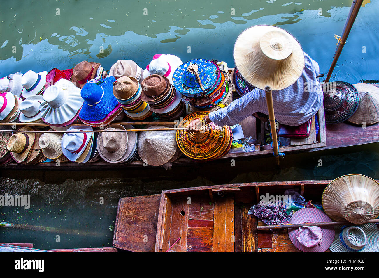 Thai dame vend des chapeaux assortis de son bateau au marché flottant  Damnoen Saduak, juste à l'extérieur de Bangkok, Thaïlande Photo Stock -  Alamy