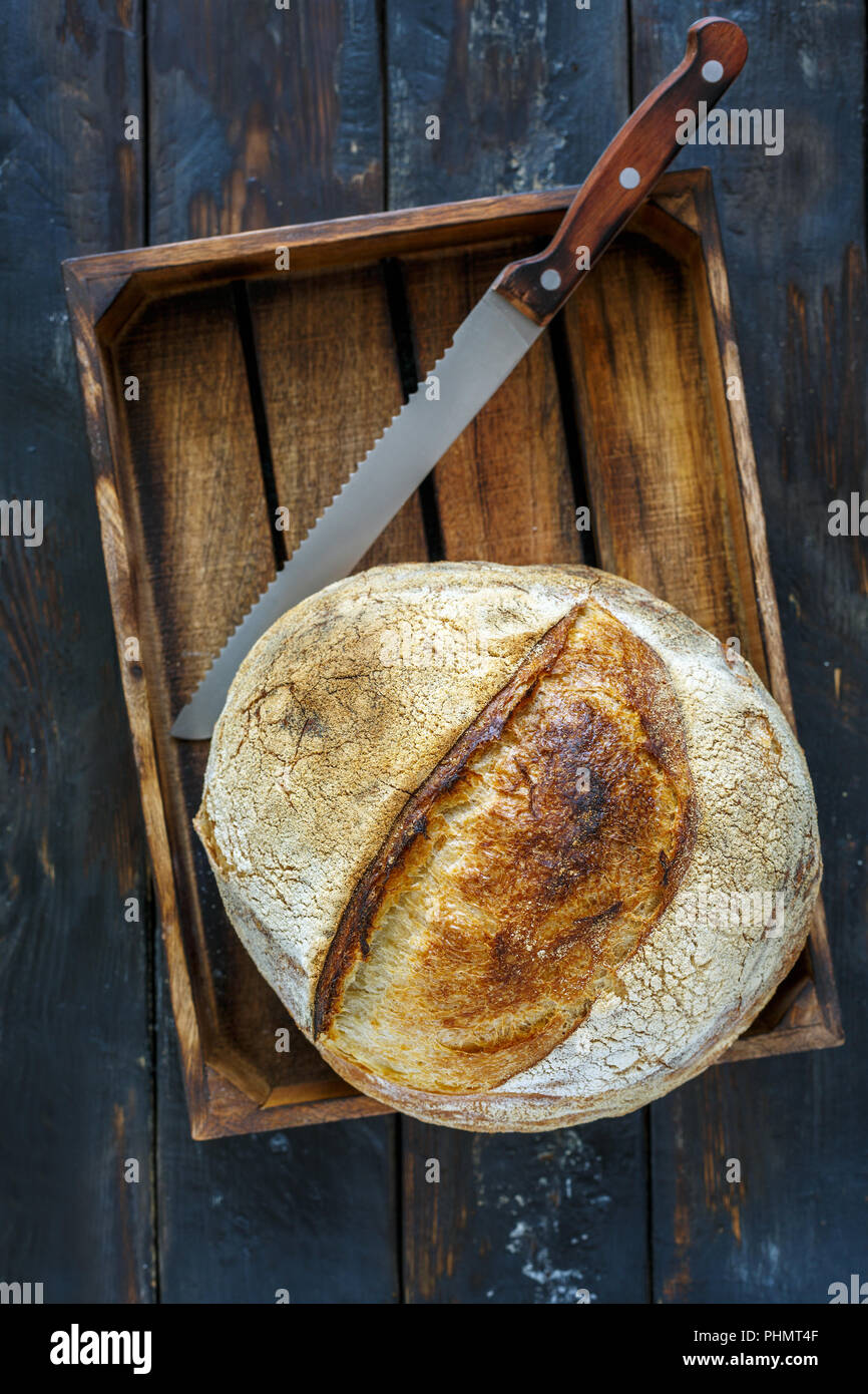 Miche de pain au levain artisanal et d'un couteau. Banque D'Images