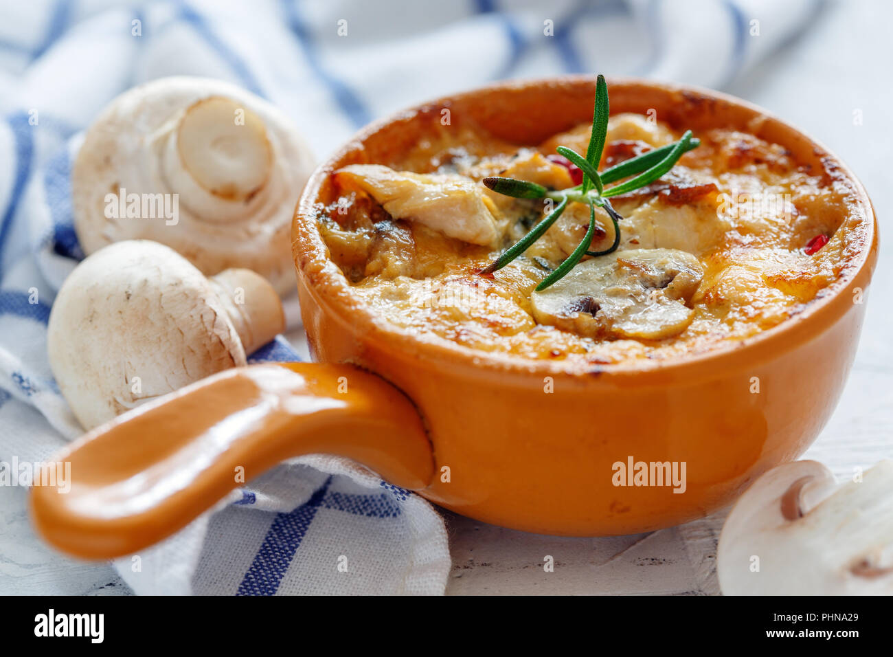 Pot en argile avec champignons sautés, poulet et fromage. Banque D'Images